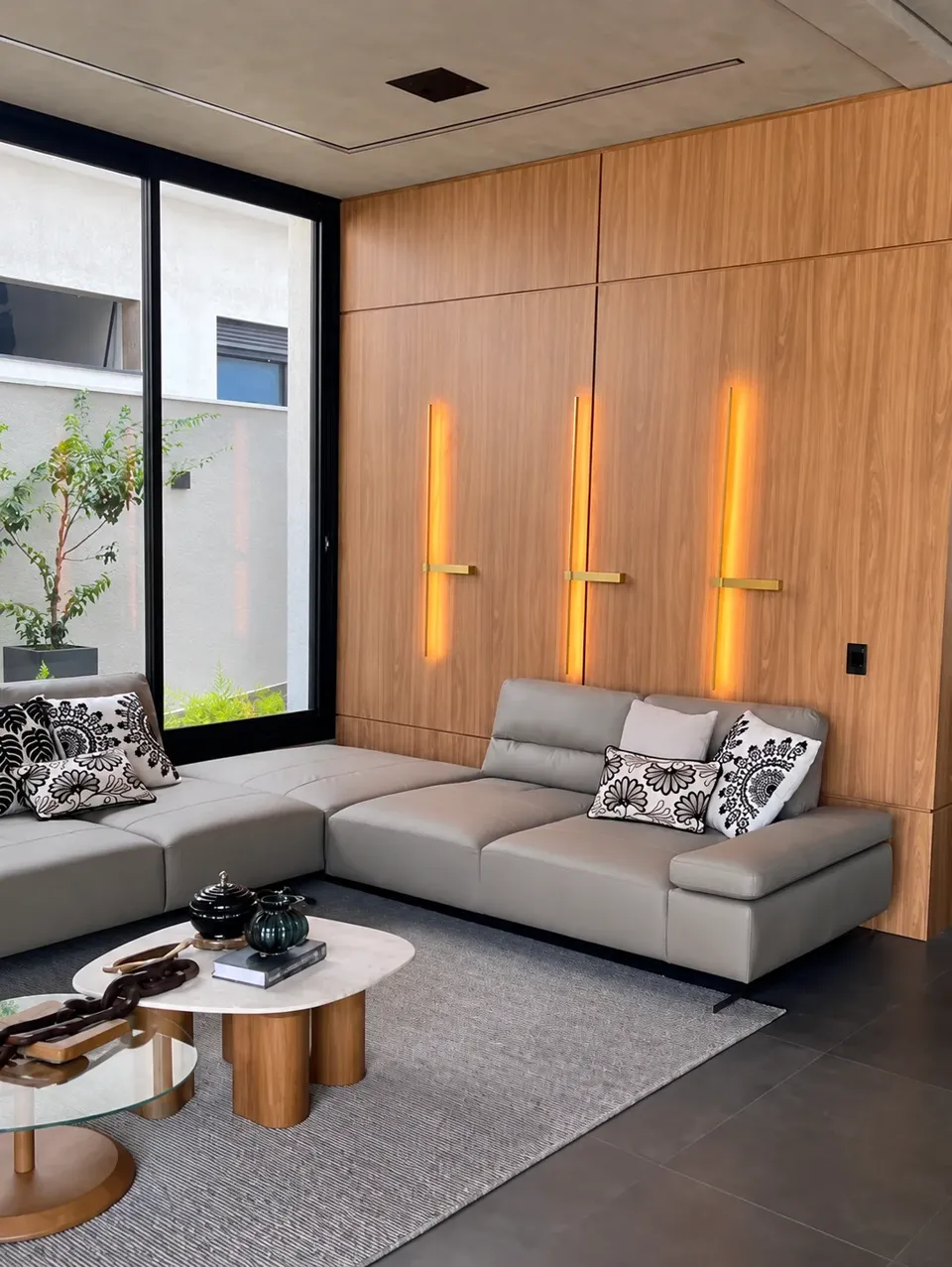 Sala com painel de marcenaria e iluminação